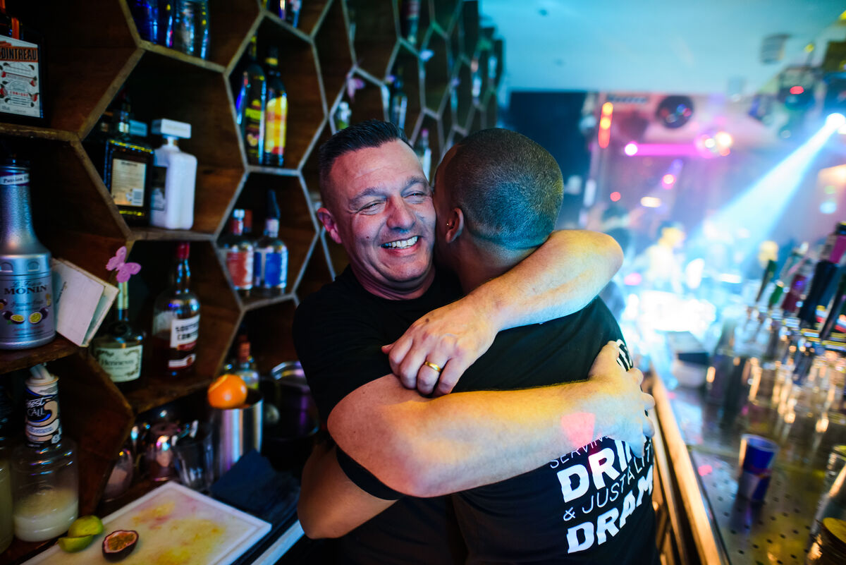 Bartender hugging a guest across the bar at Bar Blend Amsterdam