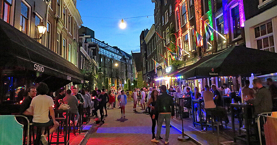 Summer evening on Reguliersdwarsstraat with terraces and rainbow-lit facades