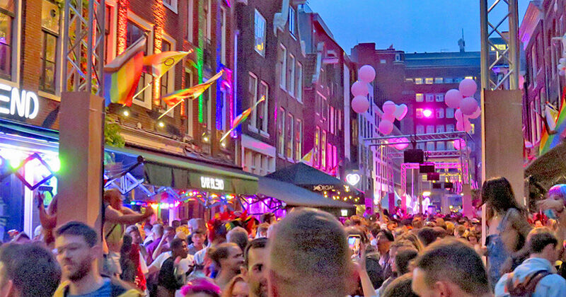 Pride crowd with balloons and rainbow flags on Reguliersdwarsstraat Amsterdam