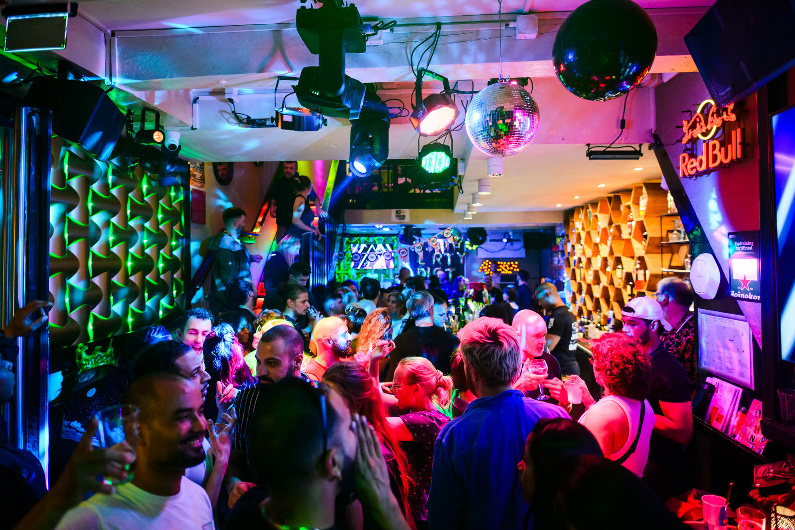 Packed crowd dancing under the disco ball inside Bar Blend Amsterdam
