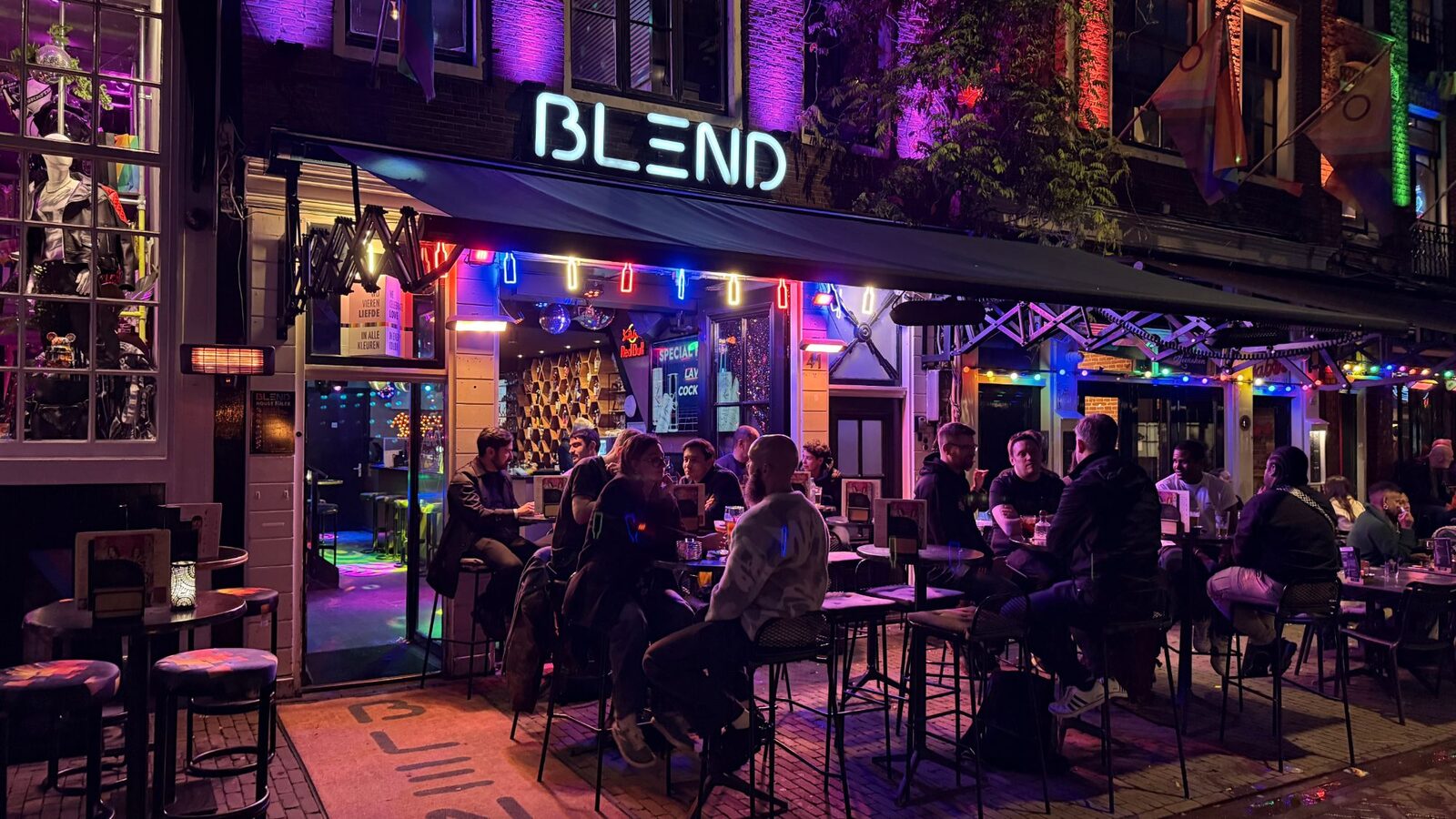 Busy terrace in front of Bar Blend at night under the neon BLEND sign on Reguliersdwarsstraat Amsterdam