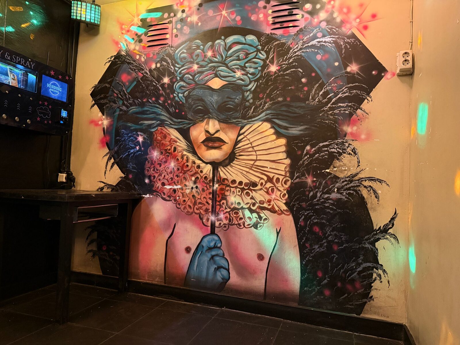 Mural of a masked figure with a lace ruff and black feathers on a wall inside Bar Blend Amsterdam