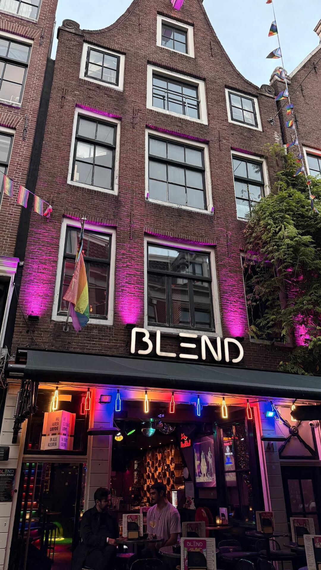 Bar Blend facade with the BLEND sign, purple uplighting and Pride flags on Reguliersdwarsstraat Amsterdam