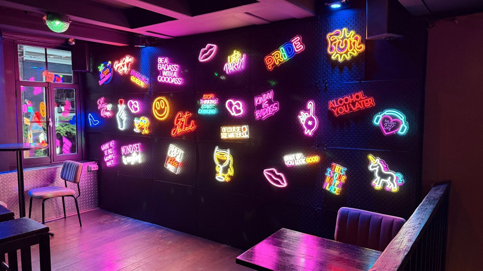 Wall of neon signs inside Bar Blend Amsterdam, with Pride, Slay Queen and Dancing Queen