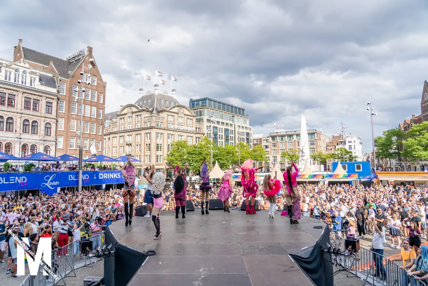 MainStage Pride festival stage on Dam Square with drag performers and a large crowd under a blue sky