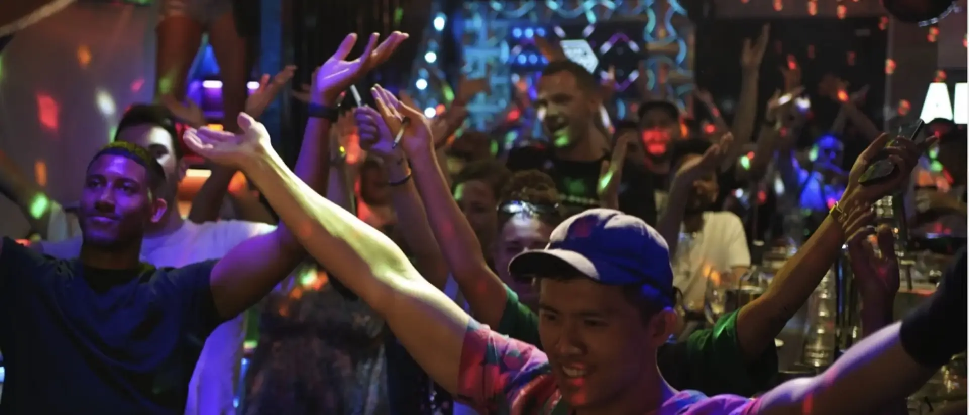 Hands in the air under disco light on a packed dance floor in Amsterdam