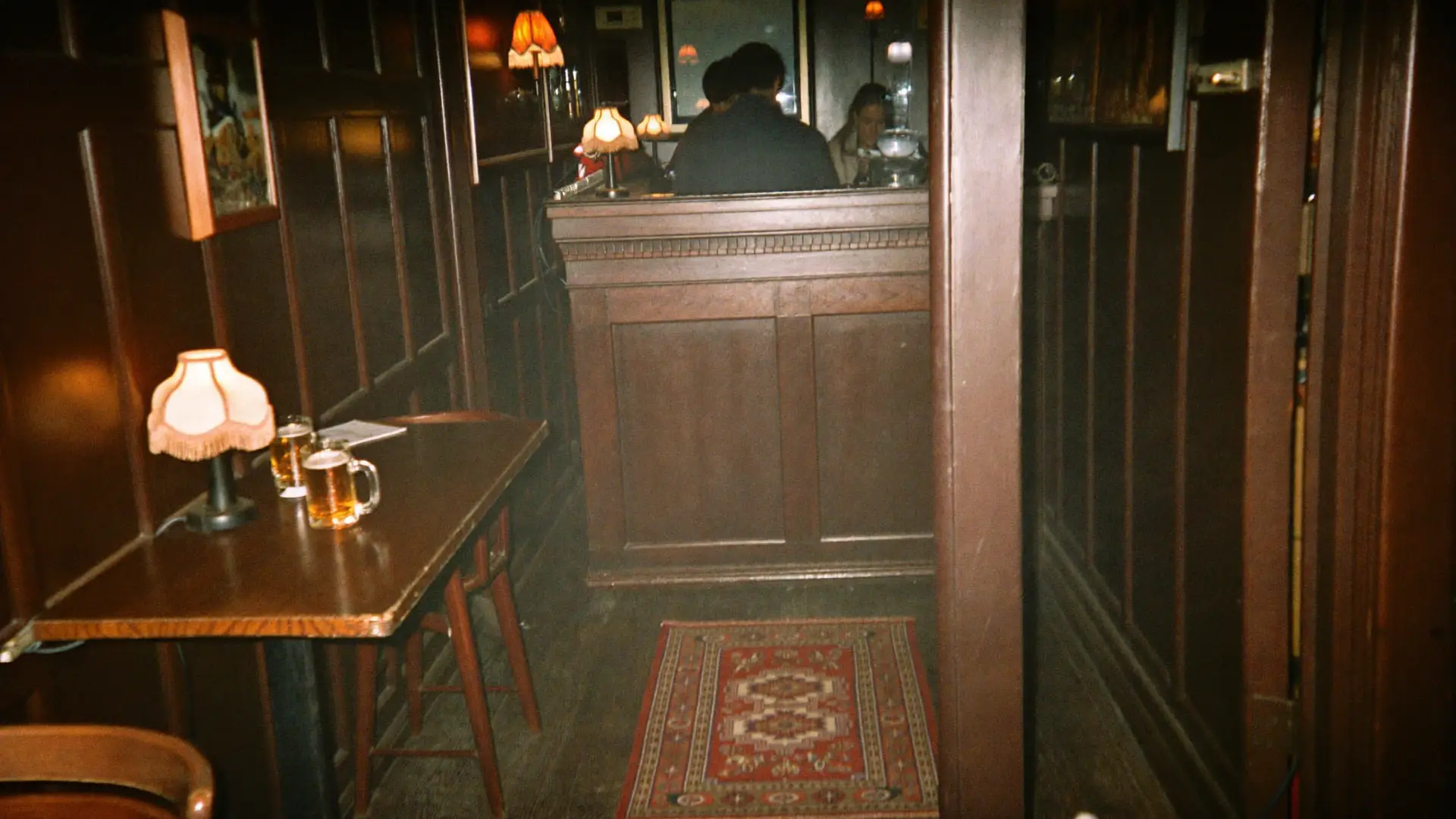 Het warme, donkerhouten interieur van een oud bruin café met schemerlampjes