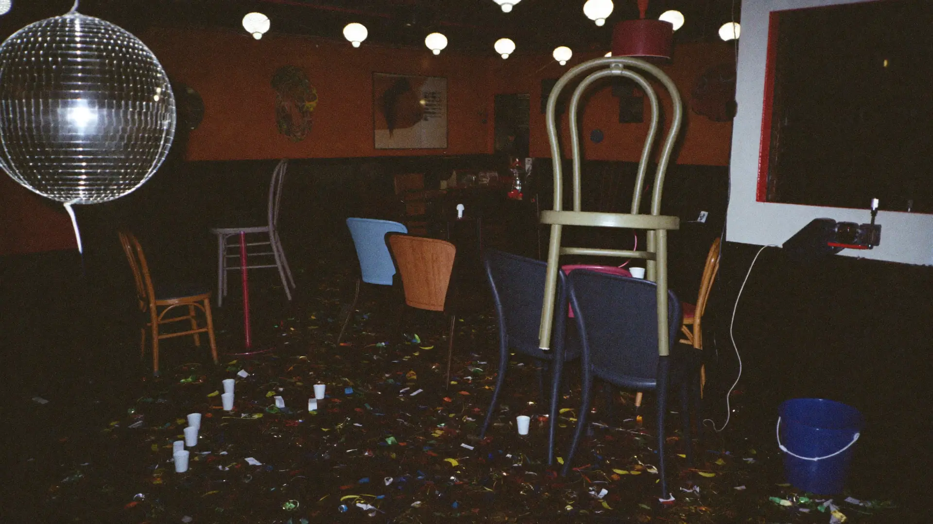 An empty club after closing with chairs on the tables and confetti on the floor