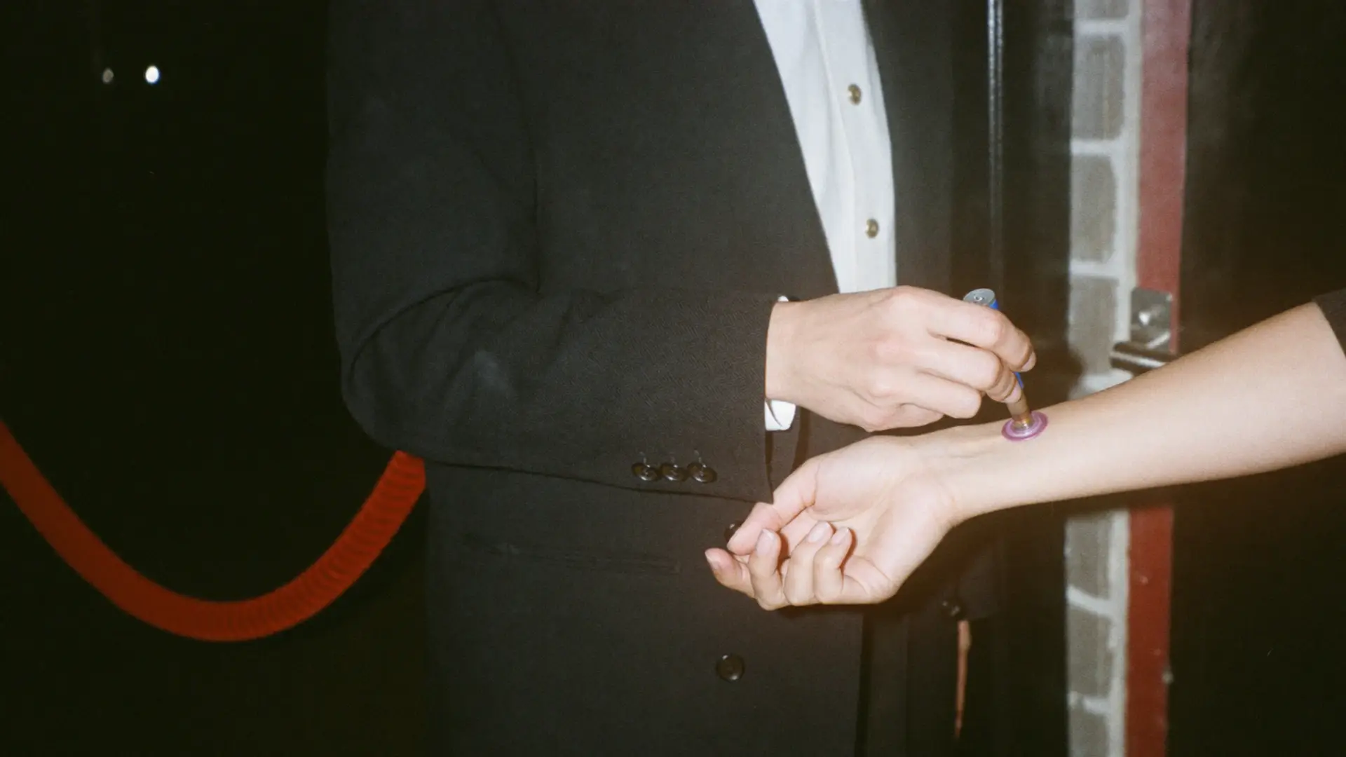 Bij de deur van een club krijgt een gast een stempel op de pols