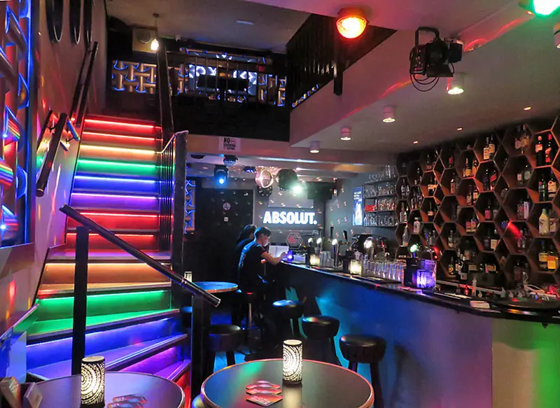 Interieur van Bar Blend met de regenboogtrap en de bar in neonlicht