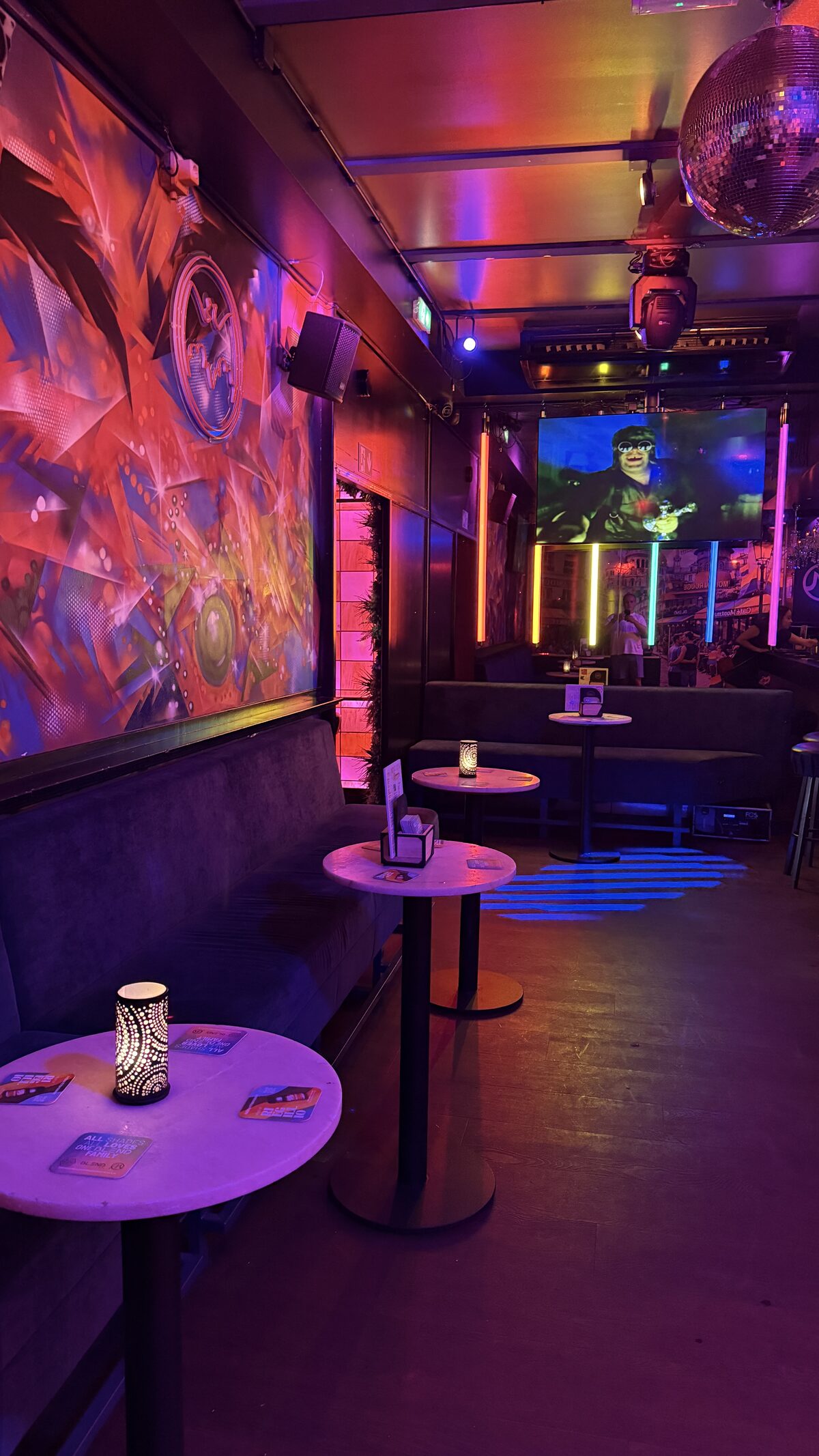 Colorful mural, neon booths and a disco ball in the back room of Montmartre XL in Amsterdam